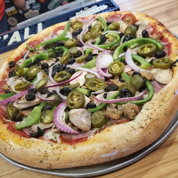 A Halftime Pizza with green peppers, black olives, red onions, mushrooms, and jalapeños.